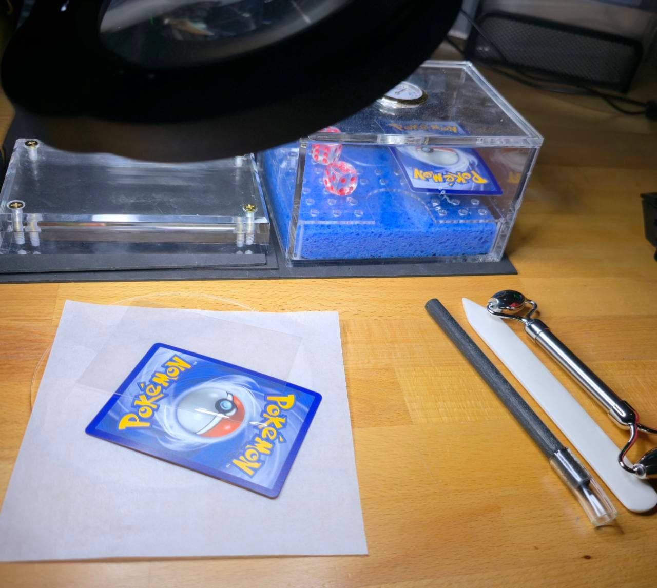 Card repair workstation with a Pokémon card, restoration tools, and a repair setup.